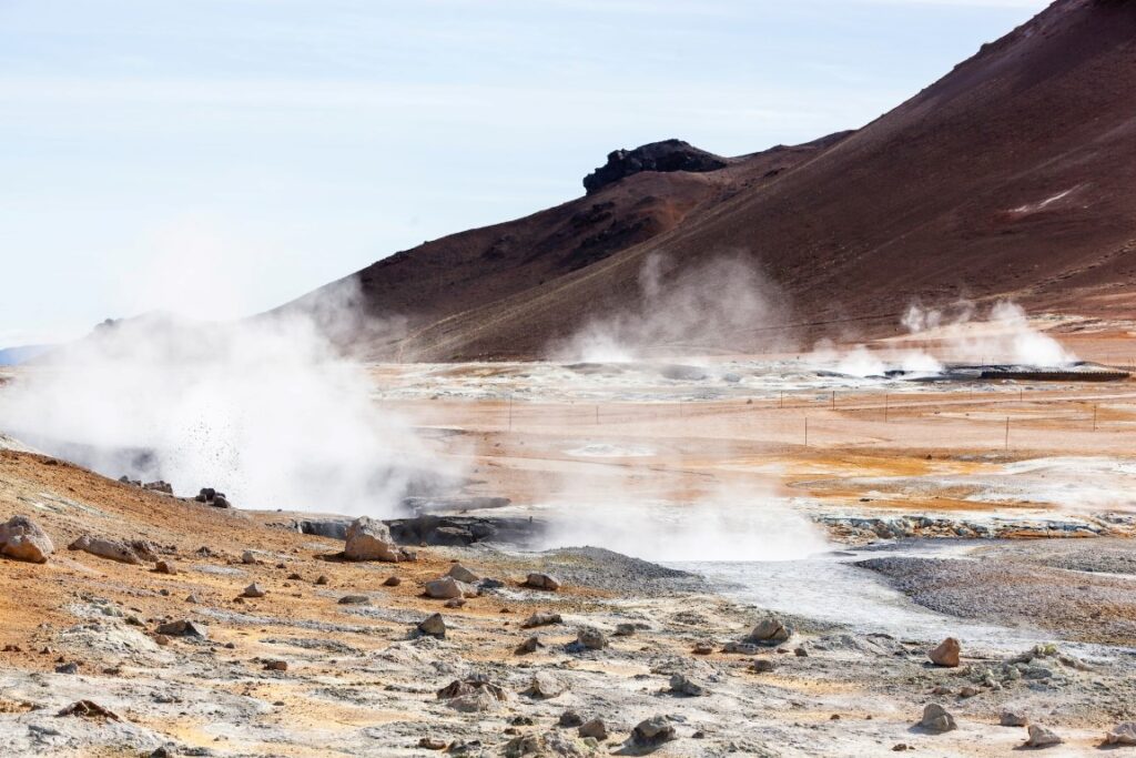 natural geothermal energy field showing steam rising from the ground