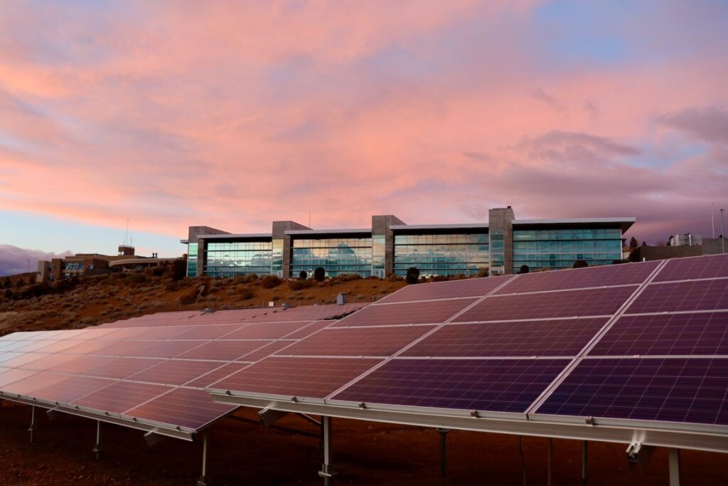 A set of solar panels against a blood-red sunset